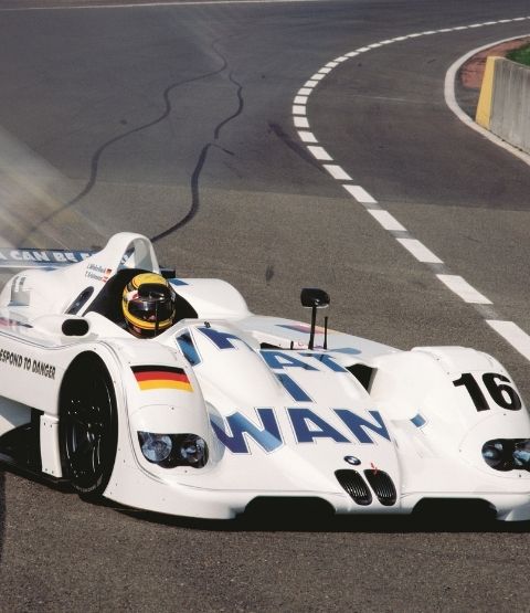Voiture de course BMW au 24 Heures du Mans, avec un pilote en action sur la piste.