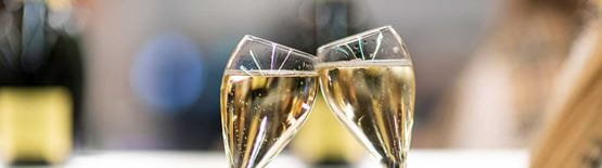 Photo de deux coupes de champagnes s'entrechoquant lors de l'avant-première du salon Rétromobile