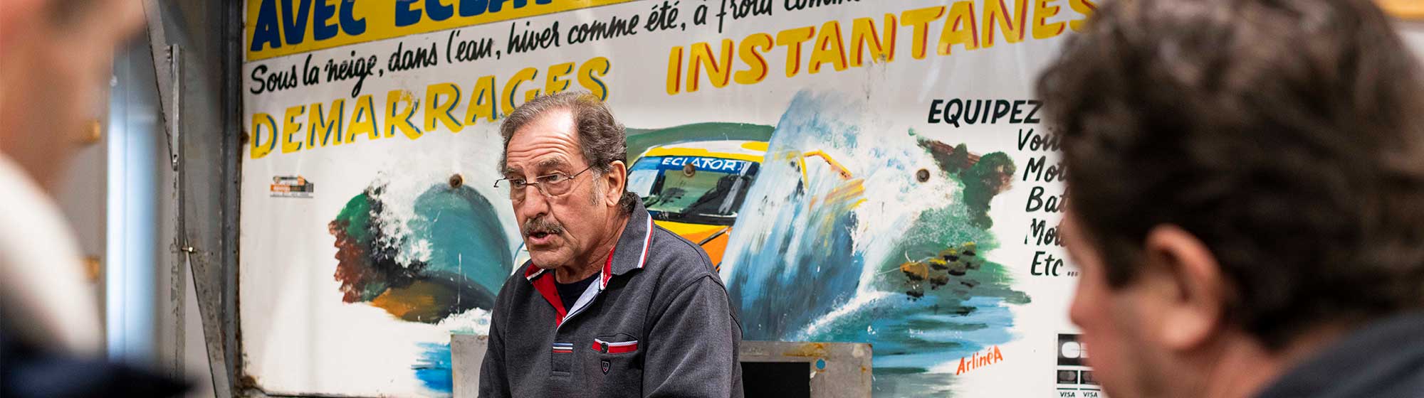 Exposant à Rétromobile discutant avec le public venu visiter son stand