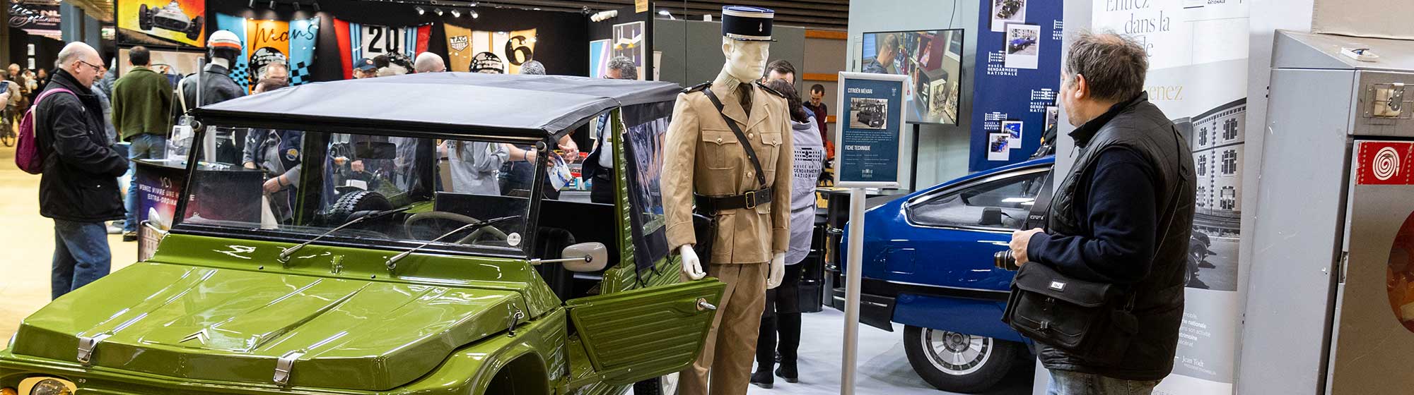 Homme regardant un manequin sur l'exposition dédié à la gendarmerie lors de Rétromobile