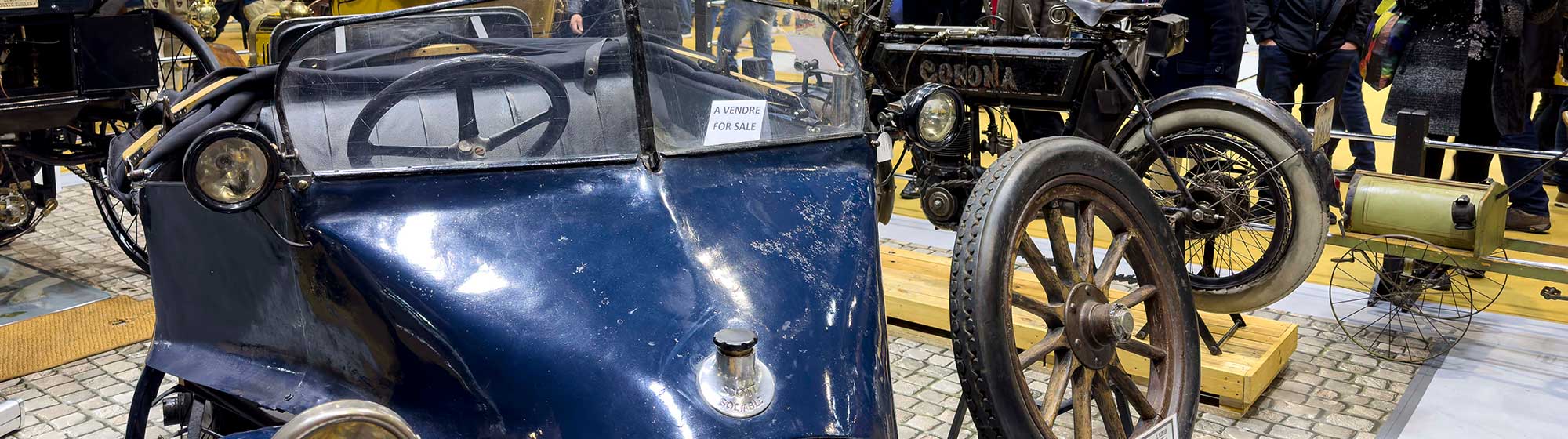 Car on display at the Rétromobile show and admired by visitors