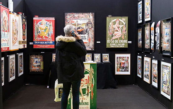 A visitor to the Rétromobile show contemplating vintage posters