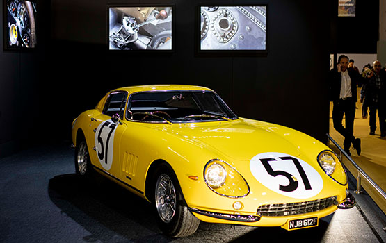 Yellow Ferrari illuminated on the Richard Mille stand at Retromobile