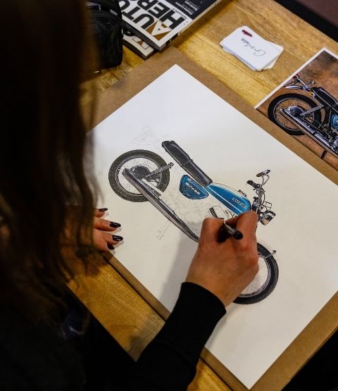 Artist painting a close-up of a motorbike