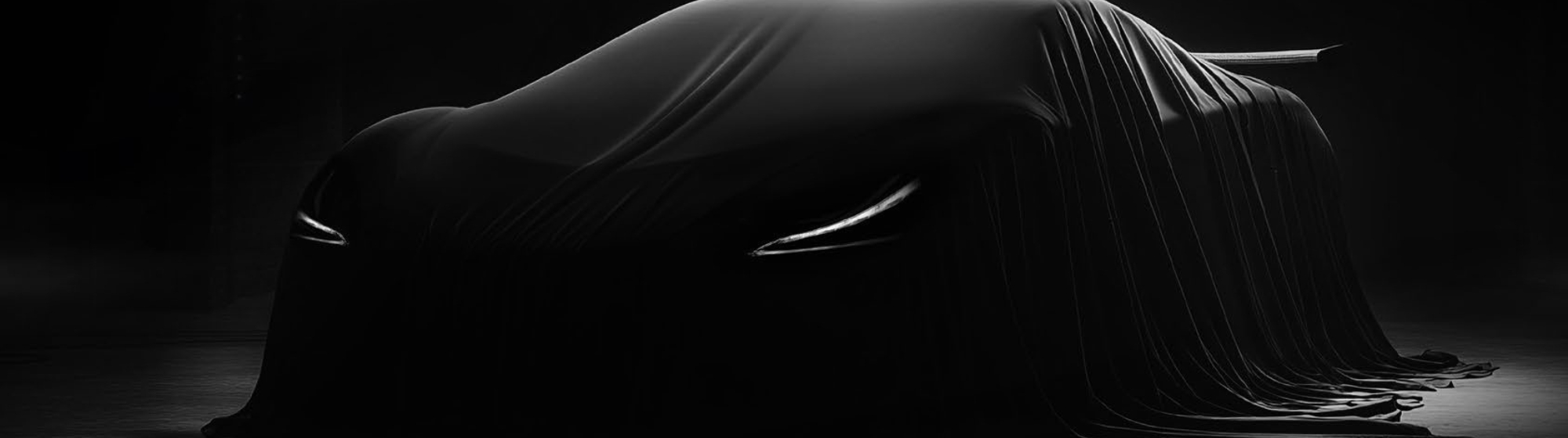 Supercar masquée sous un drap noir dans un garage sombre, phares allumés laissant deviner la silhouette