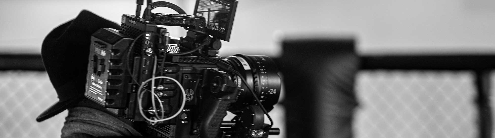 Photo en noir et blanc d'un journaliste filmant des images